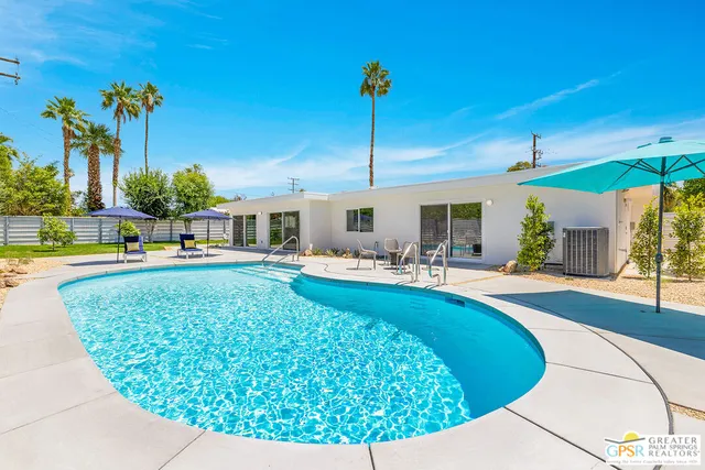 a view of a house with swimming pool and sitting area