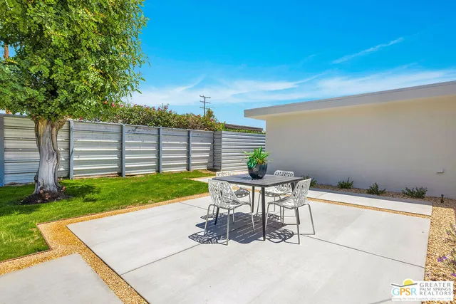 a view of backyard with a table and chairs