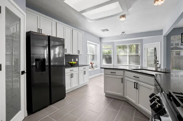 a kitchen with a refrigerator a sink cabinets and wooden floor