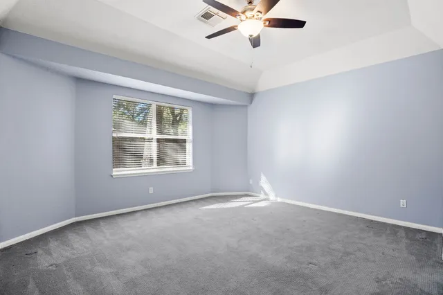 an empty room with a window and a fan