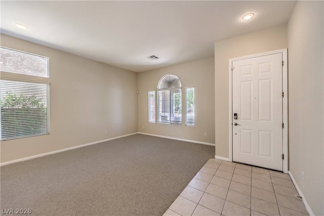 3713 Spring Shadow Road Las Vegas, NV 89129 - Photo 7 of 37 This inviting entry living space features abundant natural light and practical flooring transitions.