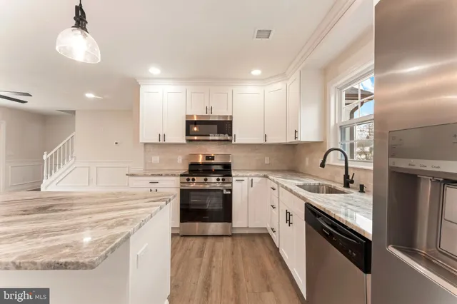 a kitchen with stainless steel appliances granite countertop a sink and stove top oven