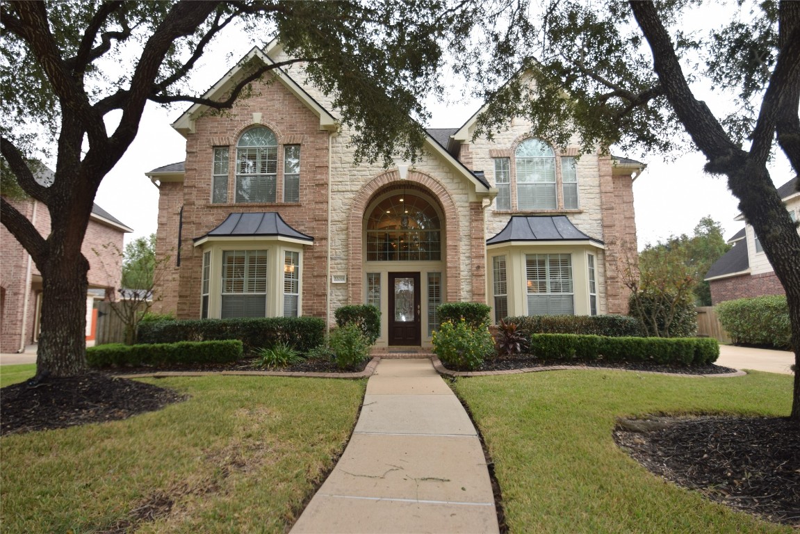 a front view of a house with yard and green space