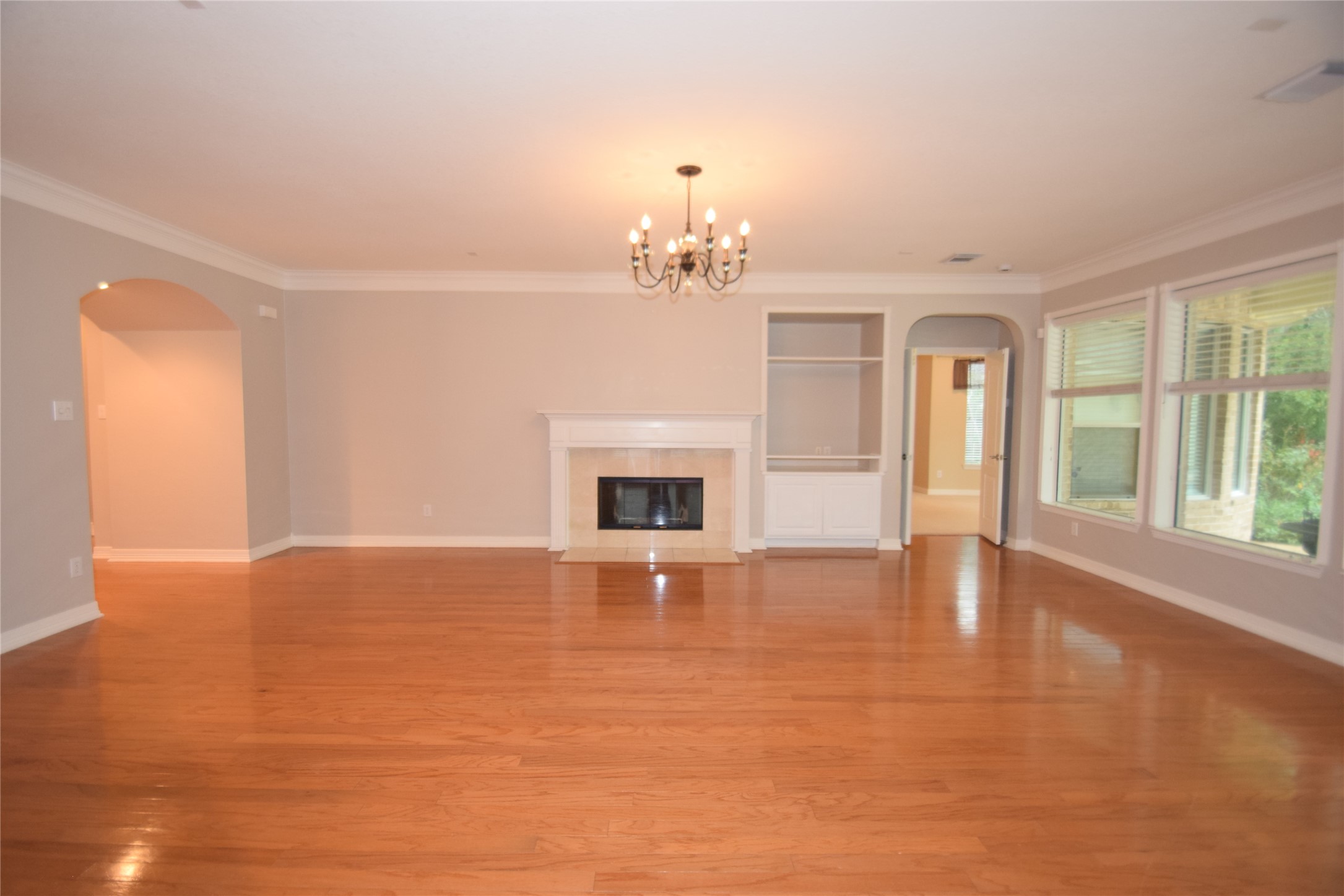 22018 Rustic Shores Lane Katy, TX 77450 - Photo 16 of 46 Fantastic family room featuring hardwood floors, crown molding, ceiling fan with light fixture, fireplace, open to the breakfast room and access to the kitchen.