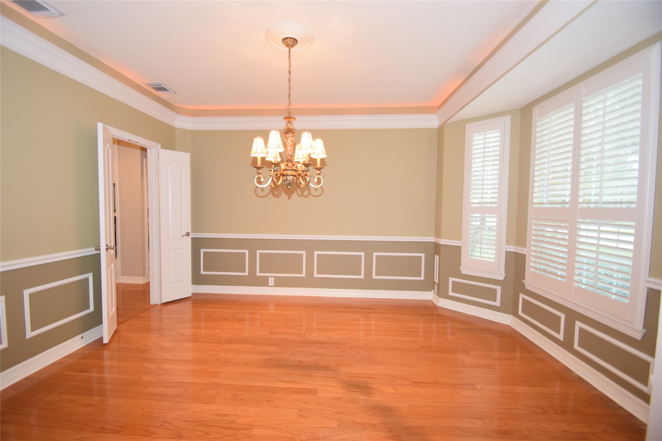 22018 Rustic Shores Lane Katy, TX 77450 - Photo 8 of 46 Dining room dazzled by hardwood floors, crown molding with accent lighting, picture frame chair rails and access to the kitchen.