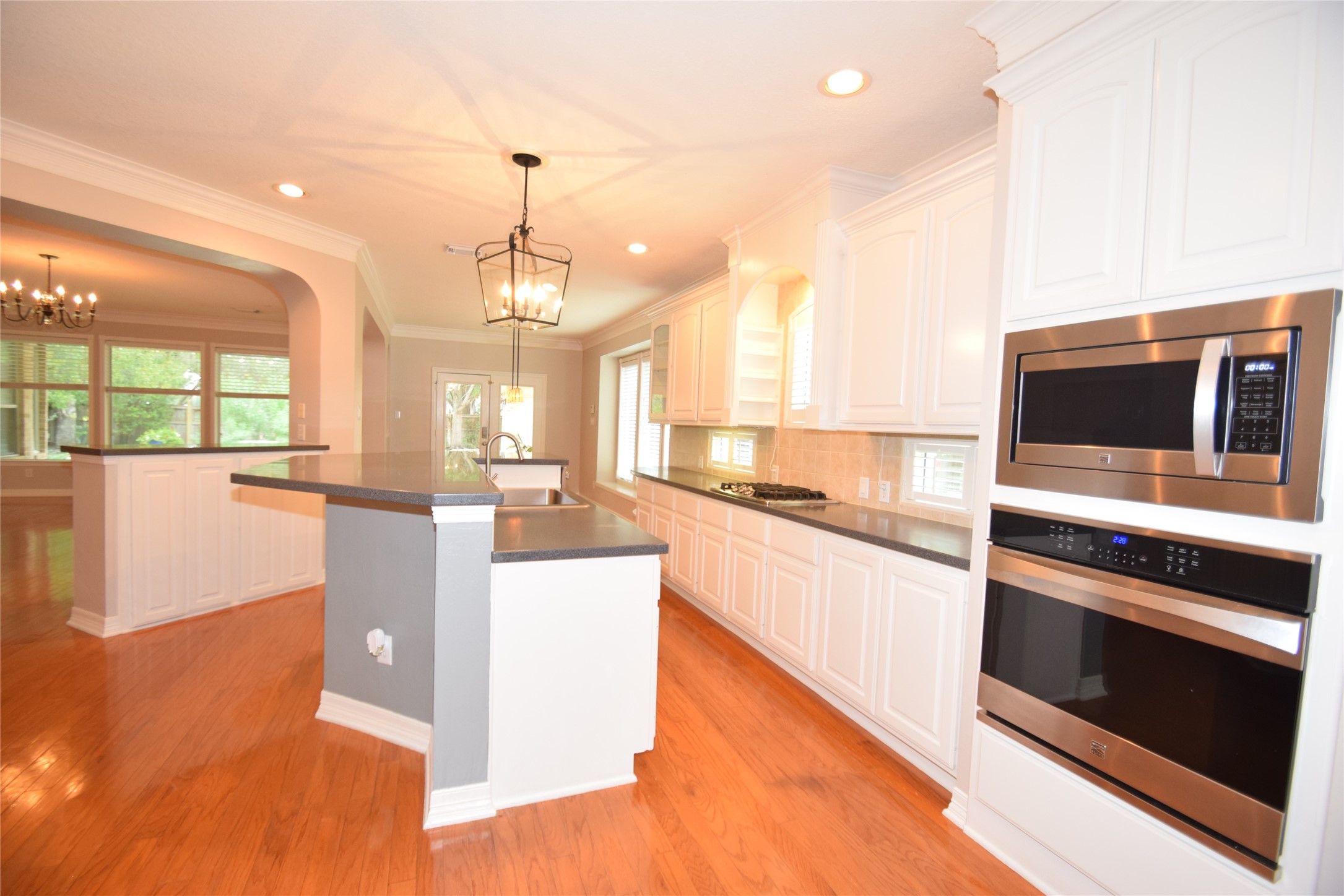 22018 Rustic Shores Lane Katy, TX 77450 - Photo 10 of 46 Kitchen offering hardwood floors, hard surface counter tops, built-in microwave and oven, gas range, raised dishwasher and a huge walk-in pantry.