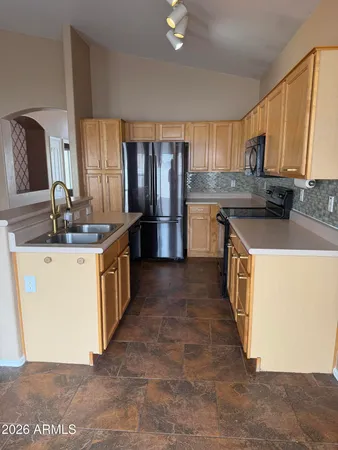 a kitchen with stainless steel appliances granite countertop a sink a stove and a refrigerator