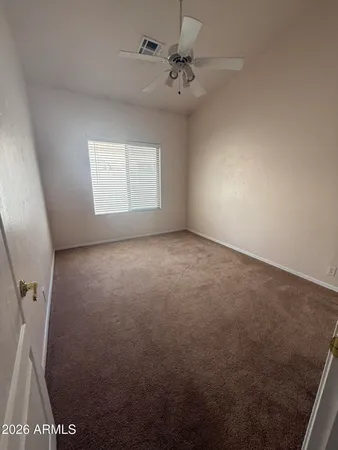 an empty room with windows and fan