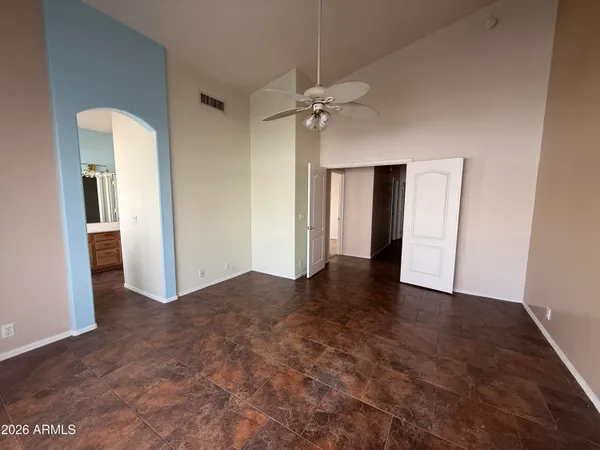 an empty room with closet and a chandelier fan