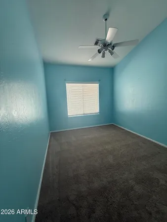 en empty room with windows and ceiling fan