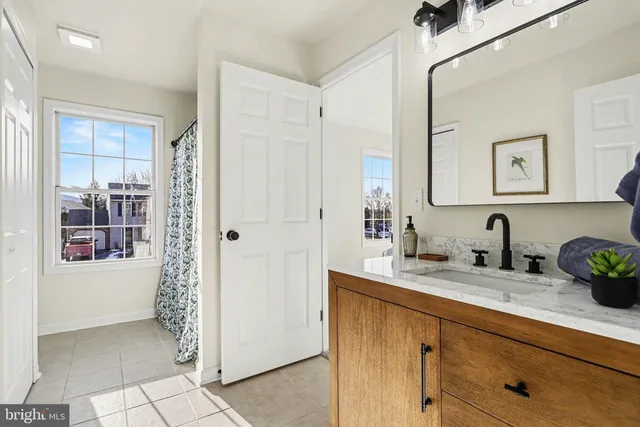 a bathroom with a granite countertop sink a mirror and a shower