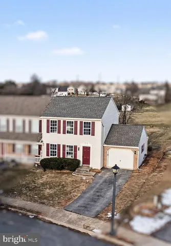 a view of a white house next to a yard with large trees