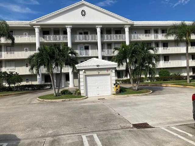 a front view of a house with a yard and palm tree