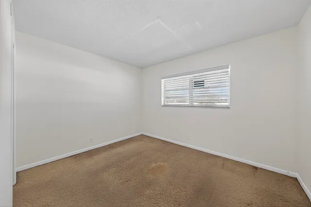 a view of a lake with a yard and large trees