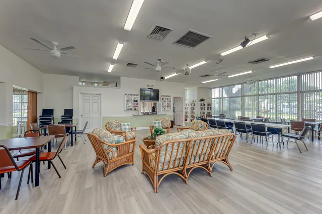 a living room with furniture kitchen view and a wooden floor