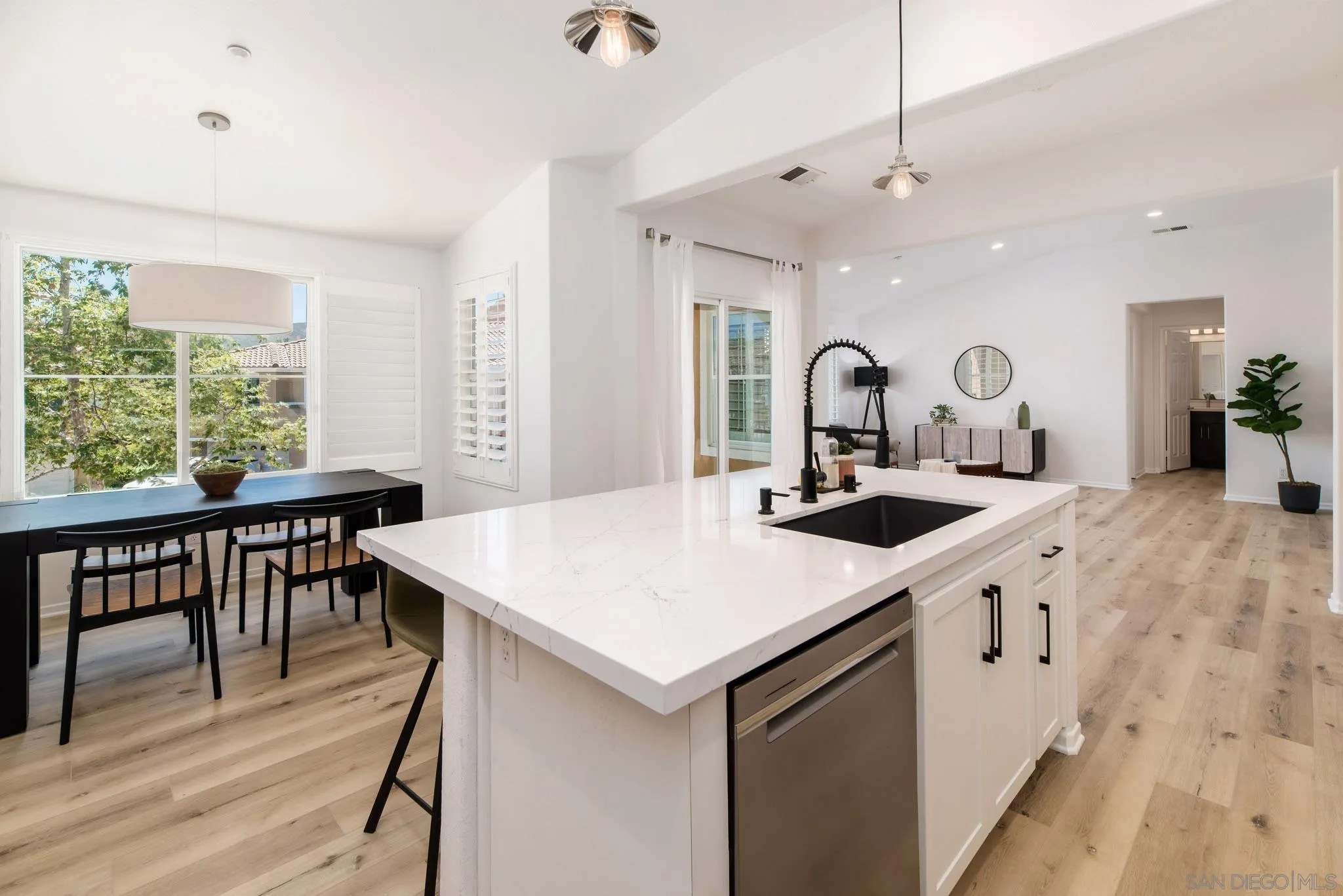 1694 Avery Road San Marcos, CA 92078 - Photo 8 of 22 a large white kitchen with a stove a sink a dining table and chair with wooden floor