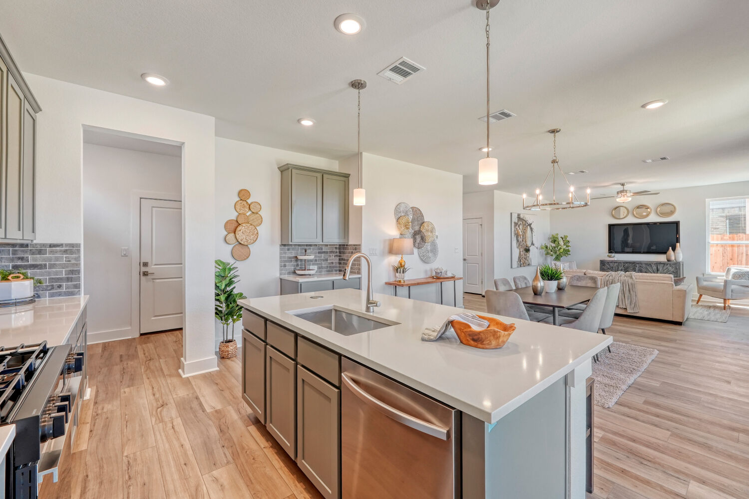 141 Sincere Drive Kyle, TX 78640 - Photo 12 of 23 a kitchen with stainless steel appliances granite countertop a sink dishwasher and a dining table with wooden floor