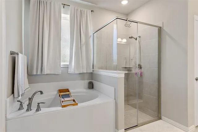 a bathroom with a tub a sink and a mirror
