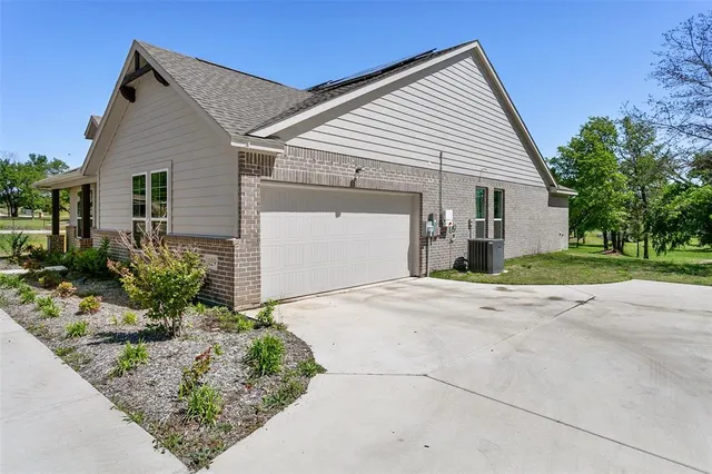 a view of a white house with a yard and plants