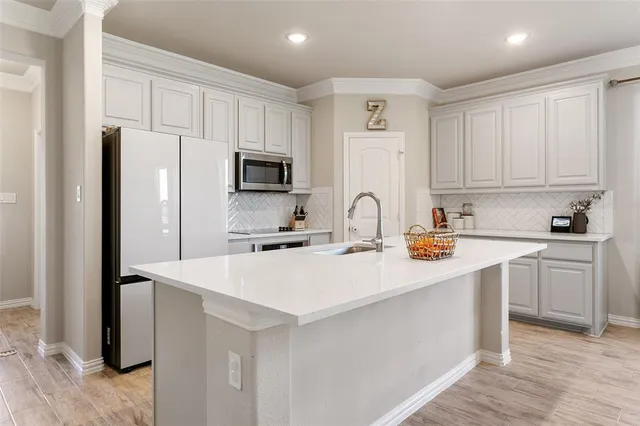 a kitchen with stainless steel appliances a refrigerator sink and cabinets
