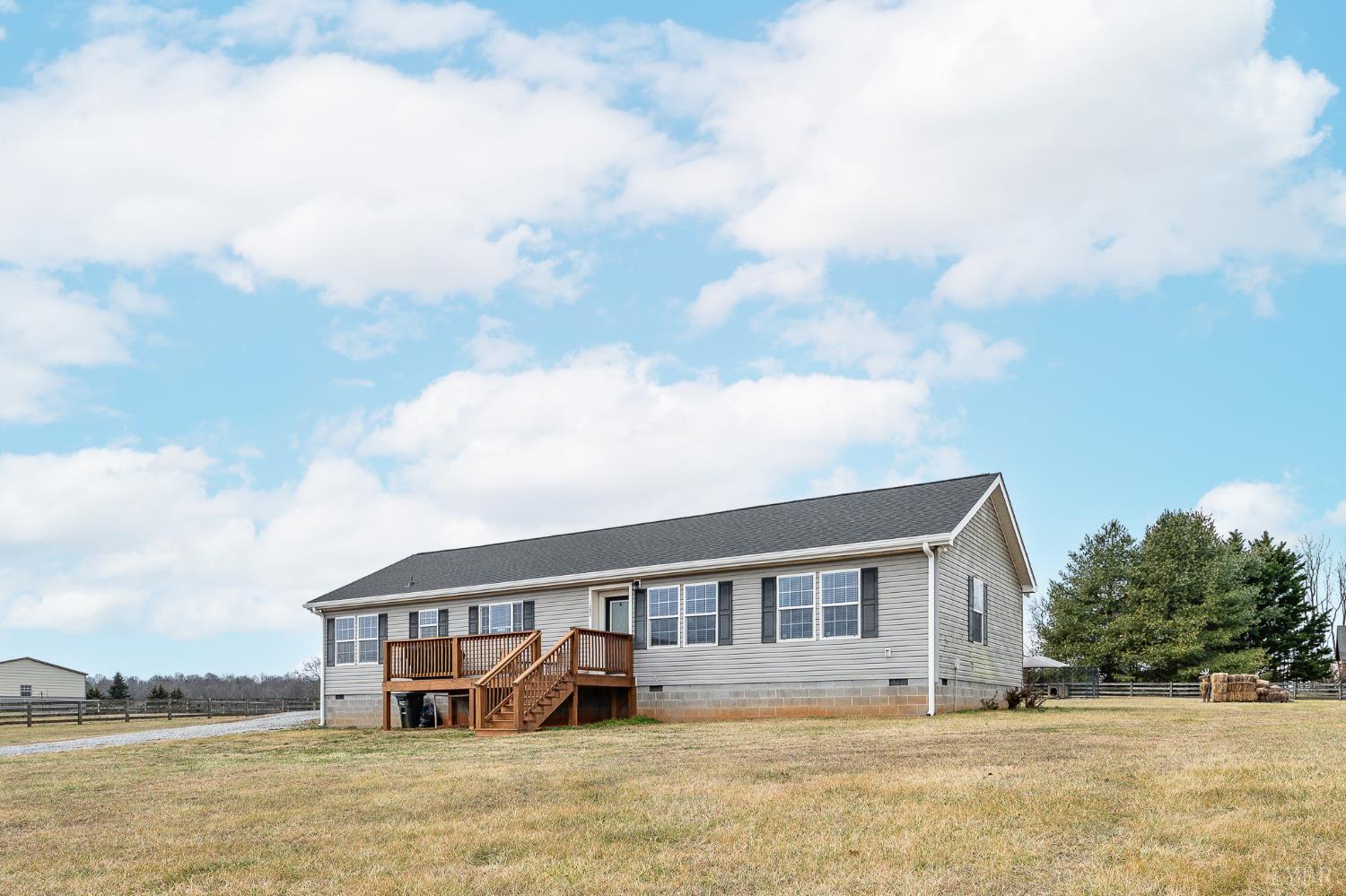 1689 Otter Hill Road Bedford, VA 24523 - Photo 6 of 45 a front view of a house with a garden and lake view