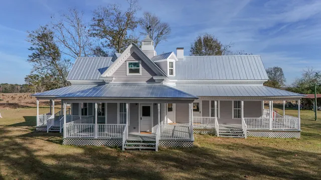a front view of a house with a garden and trees