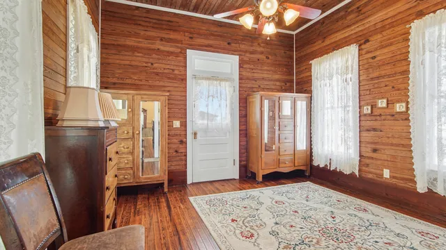 a view of a hallway with a refrigerator and wooden floor