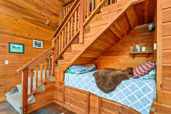 a bedroom with a bed and wooden floor