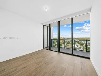 a view of hallway with a mirror and wooden floor