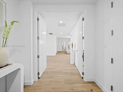 a vase of flowers sitting on a wooden floor