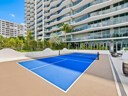 a living room with patio furniture and a potted plant