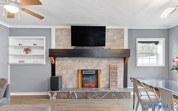 a kitchen with granite countertop a refrigerator a stove a sink a dining table and chairs with wooden floor
