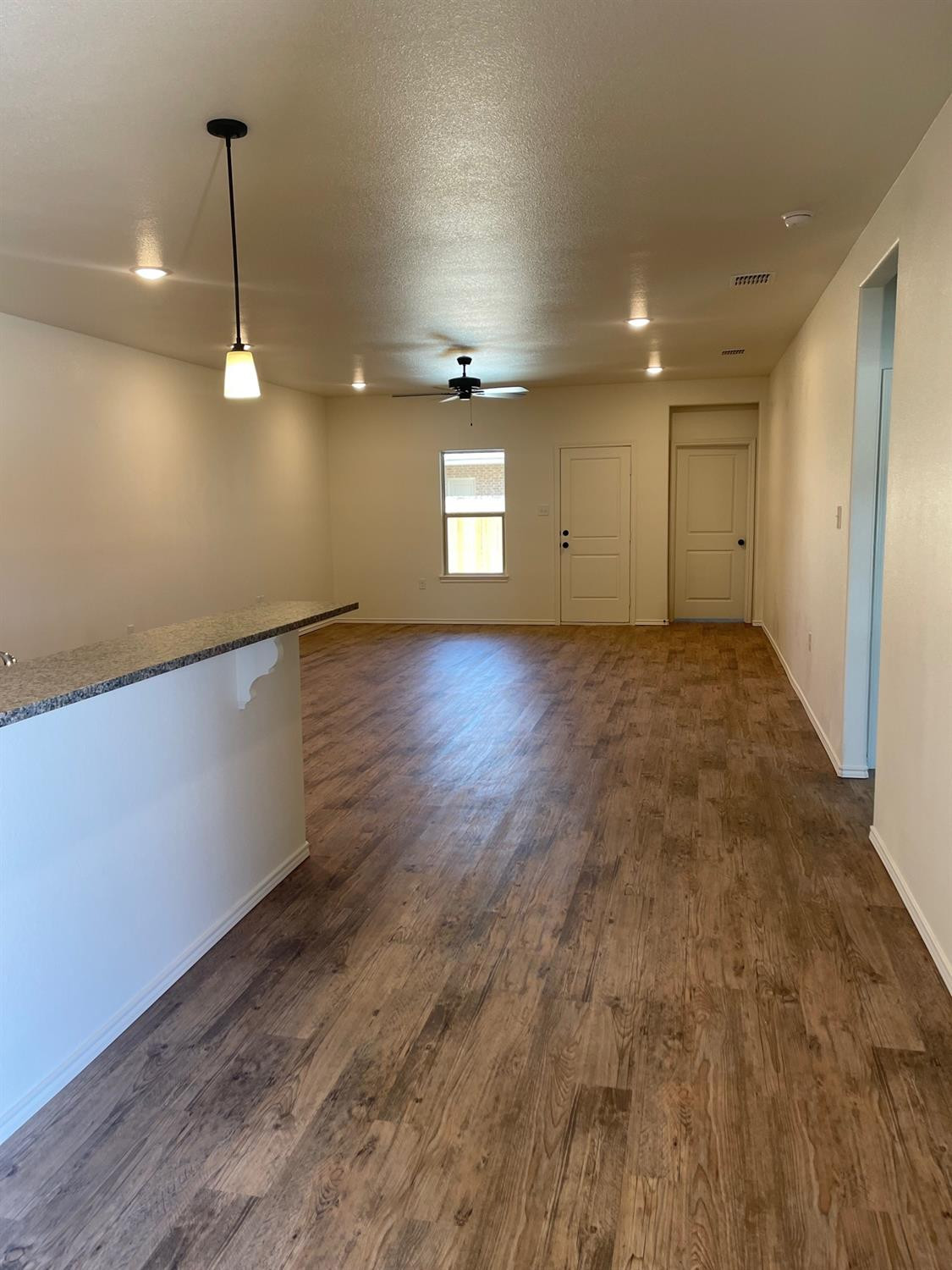 5536 Kemper Street Lubbock, TX 79416 - Photo 3 of 13 an empty room with wooden floor and windows