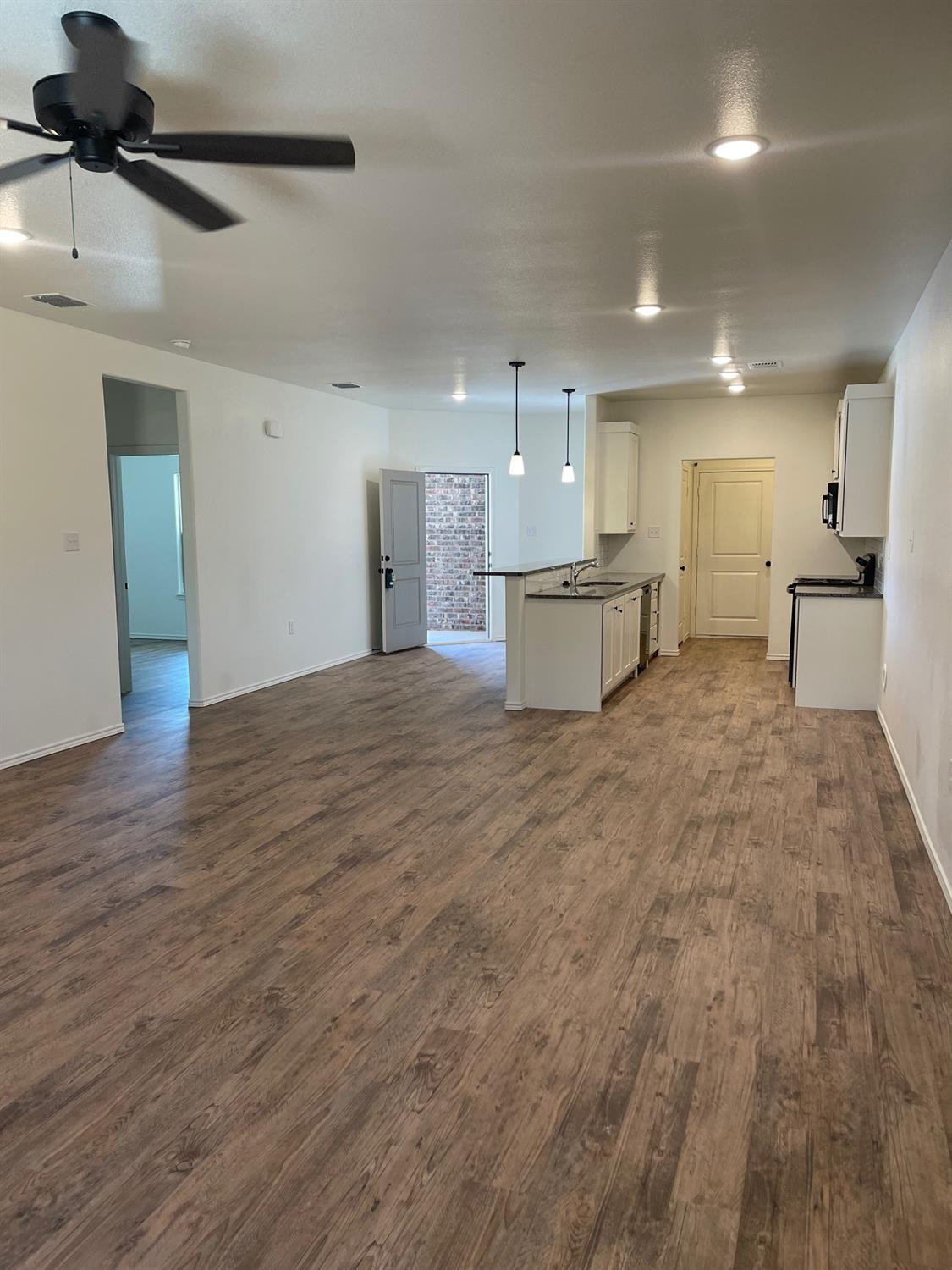 5536 Kemper Street Lubbock, TX 79416 - Photo 5 of 13 a living room with kitchen island furniture and a wooden floor