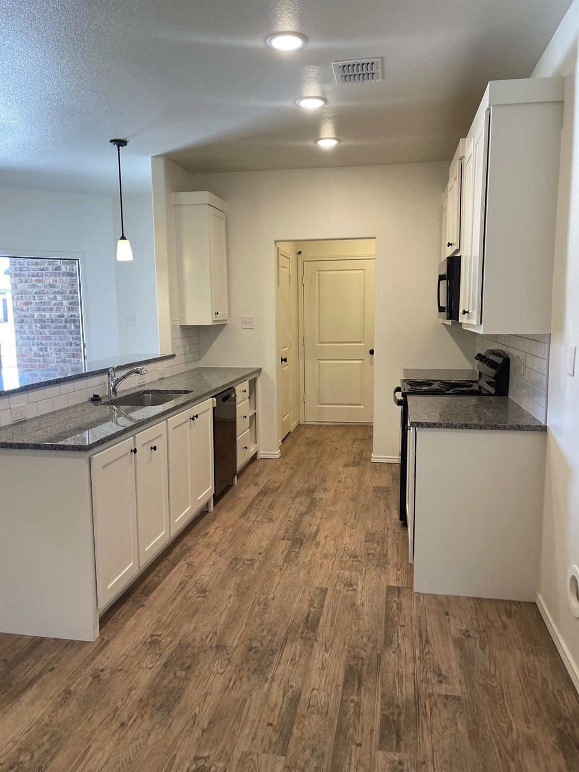 5536 Kemper Street Lubbock, TX 79416 - Photo 6 of 13 a kitchen with a sink stove and cabinets