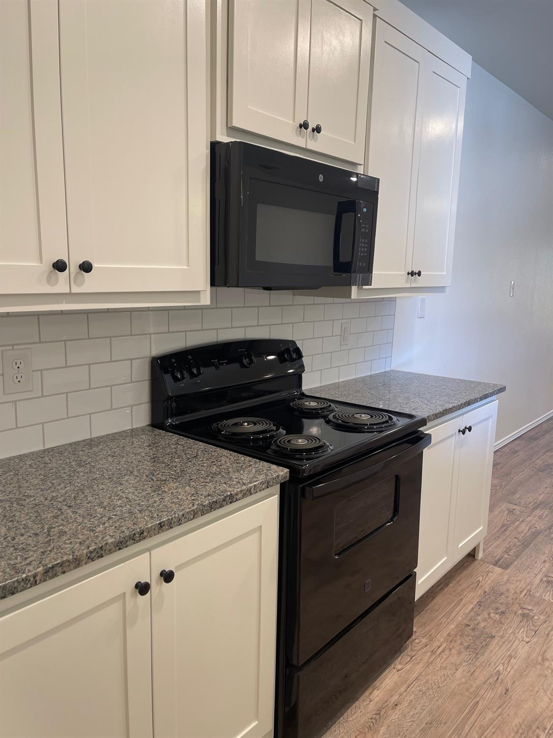 5536 Kemper Street Lubbock, TX 79416 - Photo 8 of 13 a kitchen with stainless steel appliances granite countertop a sink stove and microwave