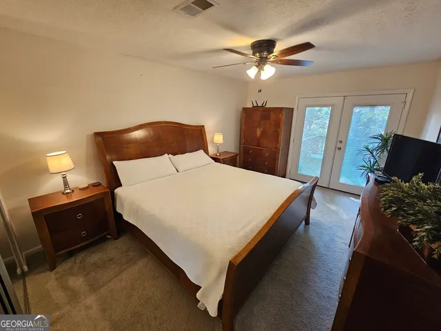 a spacious bedroom with a bed and a chandelier
