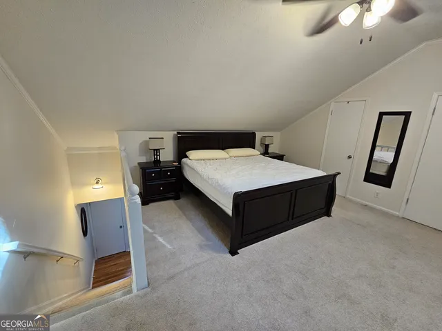 a spacious bedroom with a bed and a chandelier