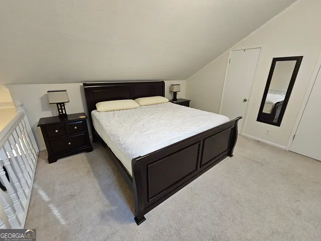 a spacious bedroom with a bed and a tv on the dresser