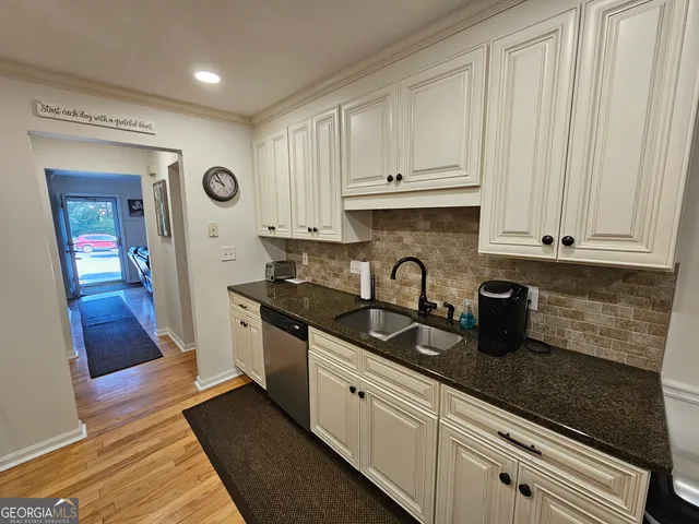 a kitchen with granite countertop white cabinets and stainless steel appliances