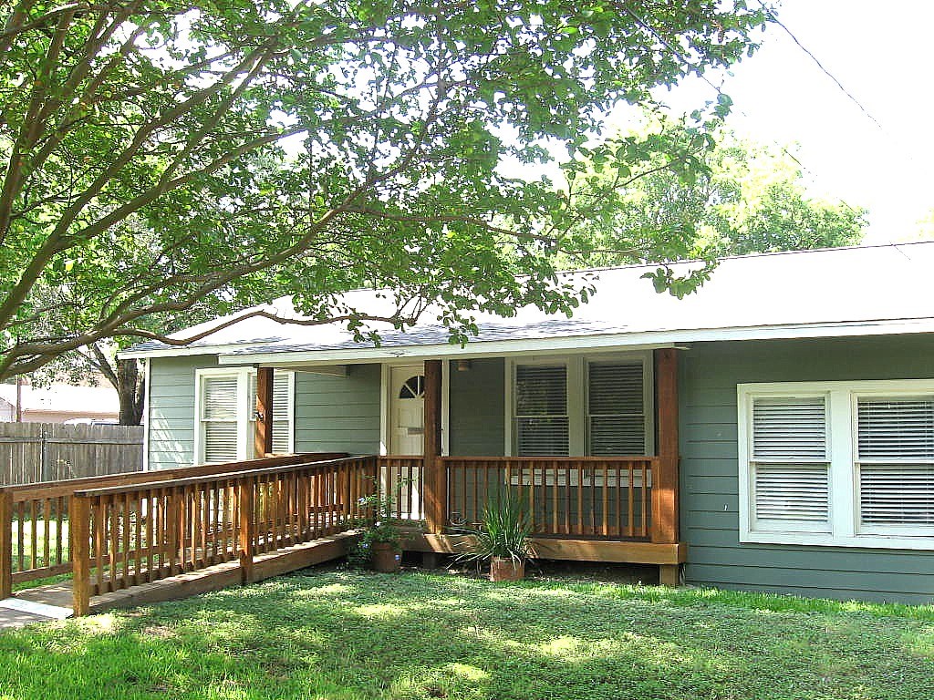 a view of backyard with deck and a garden