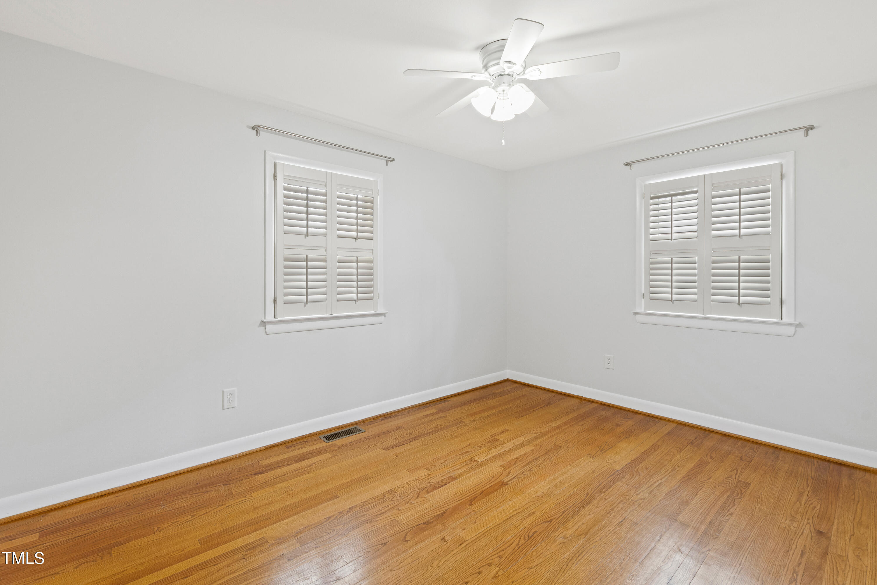 1206 Canterbury Road Raleigh, NC 27608 - Photo 21 of 37 a view of an empty room with wooden floor and a window