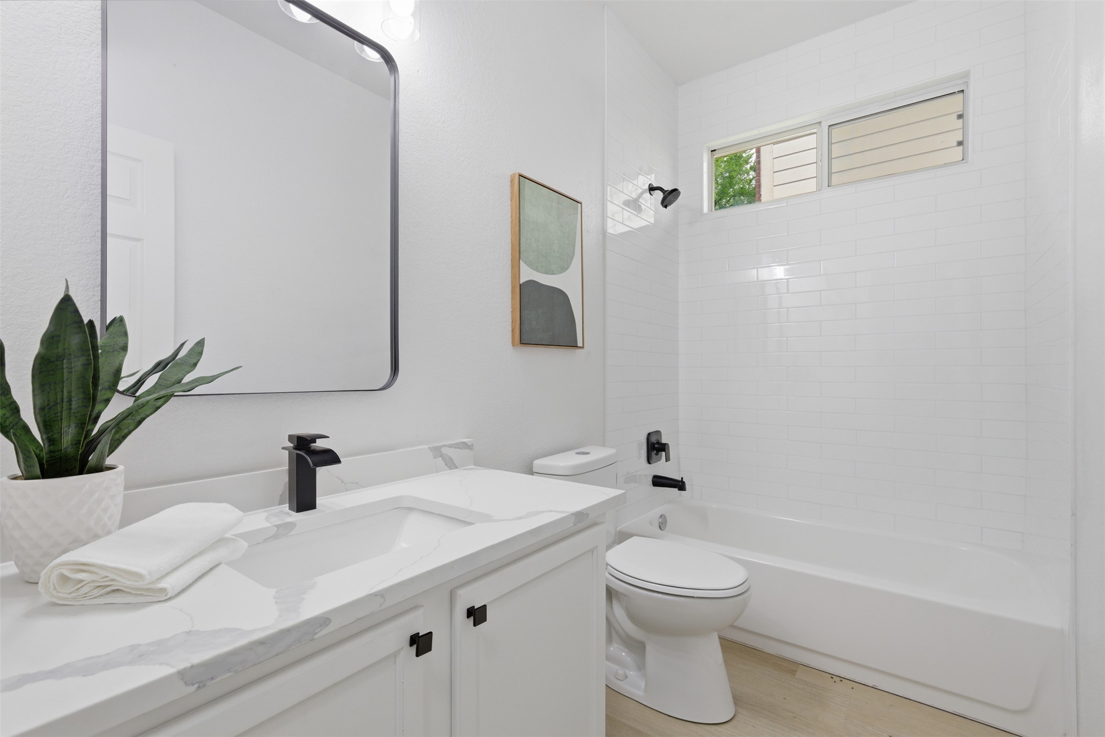 461 Hot Spring Valley Buda, TX 78610 - Photo 19 of 25 Bathroom featuring a vanity with a white countertop and a black faucet, a toilet, and a bathtub with white subway tile surround and a window