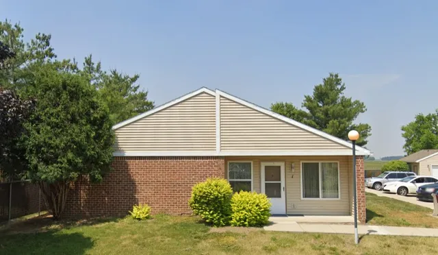 a view of a house with backyard and trees