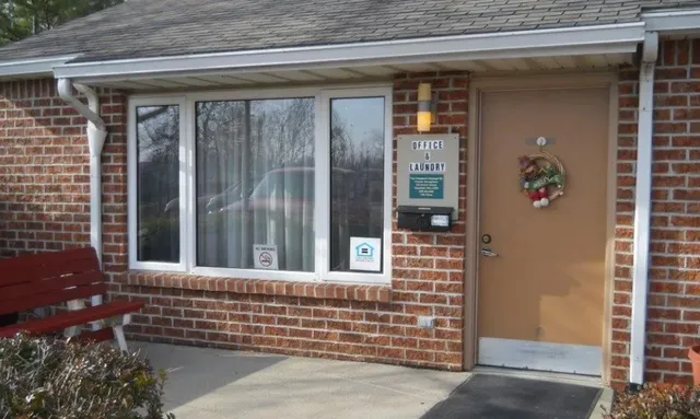 a view of a door of a house with a door and wooden bench
