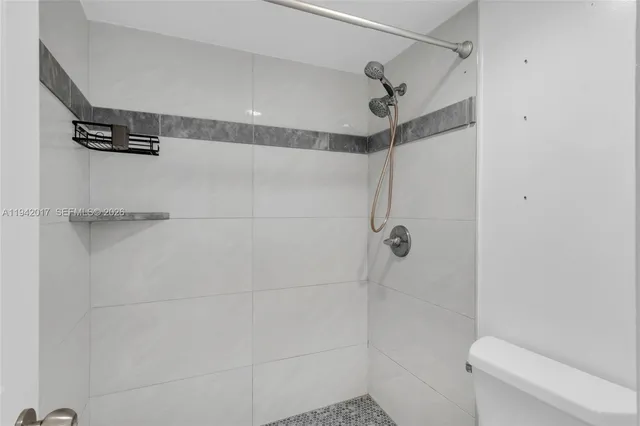 a bathroom with a shower a toilet and sink