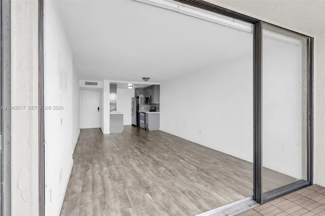 a view of empty room with wooden floor