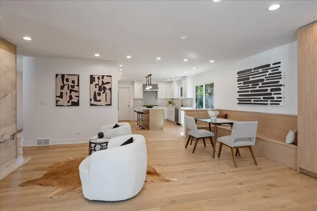 a living room with furniture a wooden floor and a refrigerator