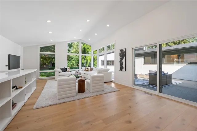 a view of a living room and kitchen floor to ceiling windows