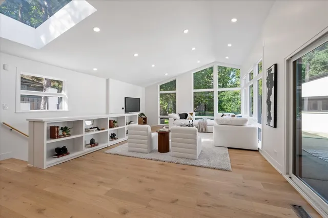 a living room with furniture large window and flat screen tv
